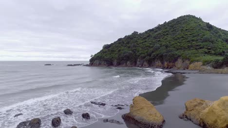 Remote-hidden-beach-on-wild-coast-of-New-Zealand-on-cloudy-day,-aerial