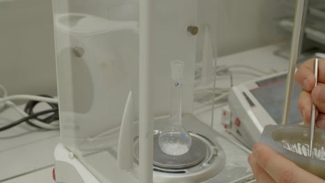 Measuring-drug-weight,-scale-with-laboratory-glassware-or-test-tube-flask,-closeup-view