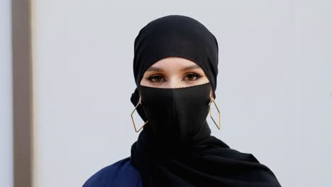 Woman-on-flu-face-mask-protecting-from-COVID19-corona-virus-during-pandemic,-wearing-burqa-shayla-and-Hijab