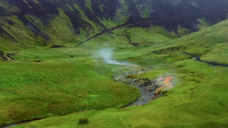 Agua-Humeante-En-El-Valle-De-Reykjadalur-Con-Vegetación-Verde-En-Islandia