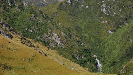 Panorama-shot-of-vast-mountain-range-with-snowy-peak-in-Fiordland-National-Park-during-summer