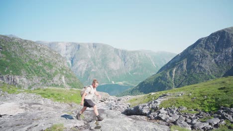 Excursionista-Con-Mochila,-Senderismo-En-El-Sendero-De-Montaña-Hacia-La-Cascada-Mardalsfossen-En-Noruega