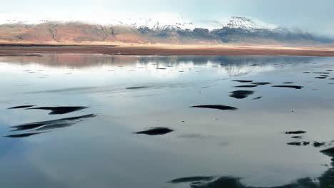 Reflejo-Del-Cielo-En-La-Superficie-Del-Agua-Con-Naufragio-En-El-Sur-De-Islandia
