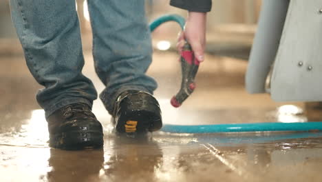 Man-Washing-Boots-With-High-Pressure-Water-Washer
