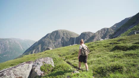 Joven-Caminando-Sobre-Prados-En-Las-Montañas-Con-Cascada-Mardalsfossen-En-Noruega