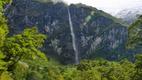 Riesiger-Wasserfall,-Der-An-Sonnigen-Tagen-Den-Berg-Hinunterstürzt,-Umgeben-Von-Grünen-Pflanzen-Und-Bäumen---Rob-Roy-Gletscher,-Neuseeland