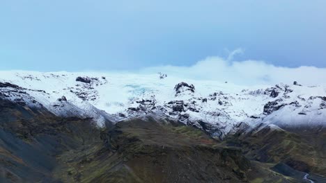 Aerial-View-Of-Haalda-With-Snow-capped-Mountain-Range-In-Background-In-South-Iceland