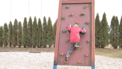 Kleiner-Junge-Klettert-Auf-Klettergerüst-Auf-Einem-Spielplatz-Stockvideo