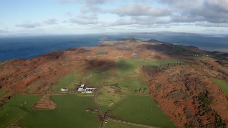 AERIAL---Beautiful-horizon-over-the-Isle-of-Gigha,-Kintyre,-Scotland,-tilt-down