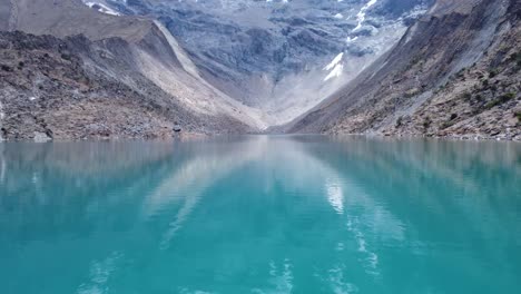 Calm-Blue-Waters-Of-Humantay-Lake-With-Rocky-Mountains-In-Peru