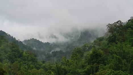 Fog-moving-in-between-mountains-over-the-rainforest-in-Sai-Yok,-Kanchanaburi,-Thailand