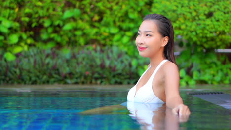 Close-up-of-a-beautiful-woman-sitting-in-the-shallow-water-of-a-swimming-pool
