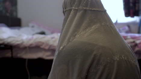 Joven-Mujer-Musulmana-Con-Hiyab-Blanco-Agachándose-Para-Orar-En-El-Dormitorio