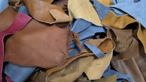 Hand-picks-up-pieces-of-leather,-close-shot
