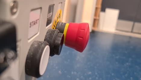 Person-pressing-red-stop-button-of-industrial-equipment,-close-up-shot