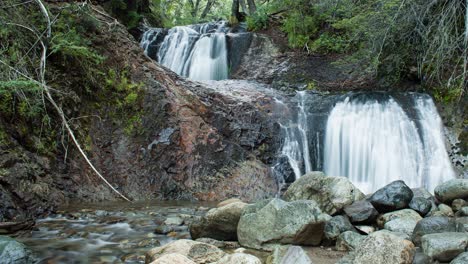 Time-Lapse-Elves-Waterfall-in-Bariloche,-Patagonia-Argentina,-with-two-waterfalls-and-a-small-stream-among-wood-and-rocks