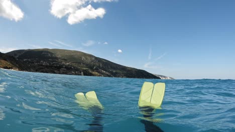 Person-With-Snorkeling-Fins-Floating-In-Blue-Ocean-In-The-Greek-Islands-Of-Kefalonia