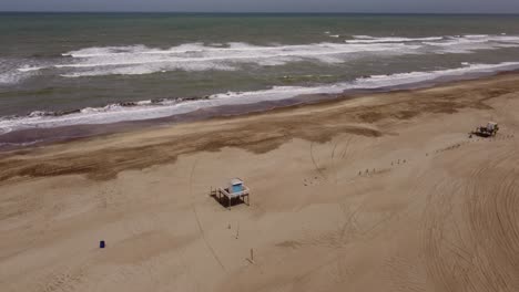 Drone-flying-over-lifeguard-tower-on-beach-at-Mar-de-las-Pampas-in-Argentina