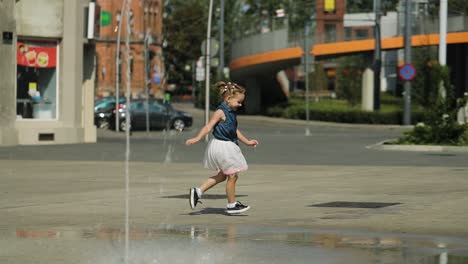 Happy-little-girl-playing-and-running-in-the-city-center-near-fountains