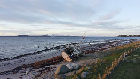 AERIAL---Shipwreck-on-a-beach,-Kintyre,-Scotland,-pan-left