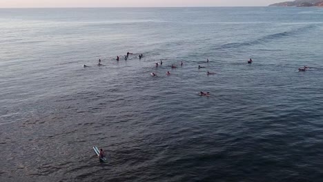 Aerial-of-a-group-of-surfers-waiting-for-waves-on-a-quiet-evening-in-Sayulita,-Mexico