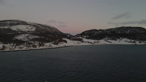 Drone-shot-flying-over-the-ocean-towards-a-mountain-range-in-Norway