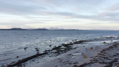 AERIAL---Shipwreck-on-a-beach,-Kintyre,-Scotland,-wide-reverse-shot