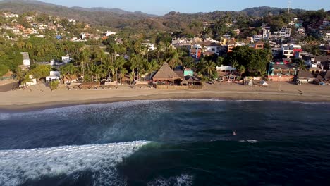 Aerial-view-of-Sayulita-during-sunset-with-surfers-in-the-water
