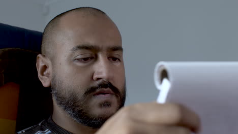 A-close-up-shot-of-an-Indian-man-flicking-through-the-pages-of-his-notepad-as-he-searches-through-his-meeting-notes-to-find-the-information-and-detail-he-is-looking-for
