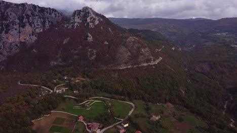 Aerial-forward-view-of-magnificent-red-valley-with-its-Pietraroja-mountains-and-village