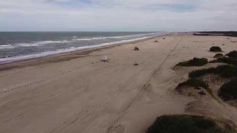 Isolated-4x4-car-driving-along-desert-beach,-Mar-de-las-Pampas-in-Argentina
