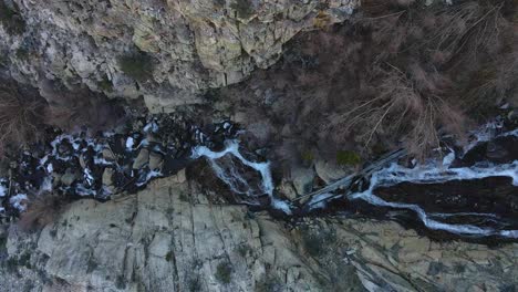 Aerial-of-a-river-a-waterfall-with-water-coming-down-from-the-mountains