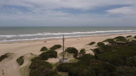 Orbiting-aerial-view-of-radio-antenna-on-beach