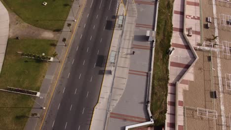 Top-down-view-of-a-man-running-on-the-street-of-Mar-del-Plata-in-Argentina-on-a-sunny-day-in-a-natural-background-beside-the-road-of-vehicles