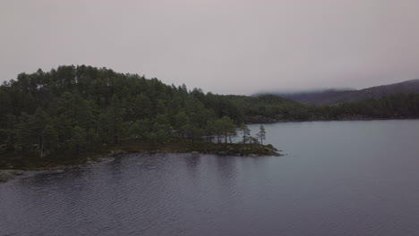 Luftaufnahme-Von-Dichtem-Nebel-Und-Wolken,-Die-Einen-Wald-Und-Einen-See-In-Norwegen-Bedecken