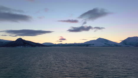 Drohne-Fliegt-über-Den-Ozean-Mit-Blick-Auf-Die-Berge-Bei-Sonnenuntergang,-Norwegen