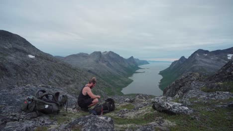 Joven-Excursionista-Activo-Con-Malamute-De-Alaska-En-El-Paisaje-Montañoso-Del-Parque-Nacional-Anderdalen-En-Senja,-Noruega