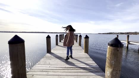 Girl-walking-on-a-deck-pier-at-a-lake