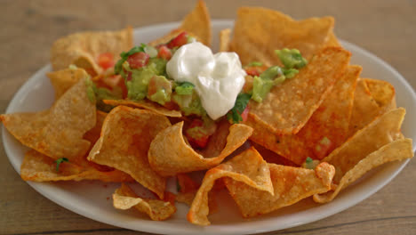 Mexican-nachos-tortilla-chips-with-jalapeno,-guacamole,-tomatoes-salsa-and-dip