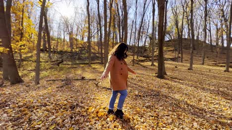 Mädchen,-Das-Im-Herbst-In-Minnesota-Auf-Einem-Wald-Spaziert,-Wobei-Gelbe-Blätter-Fallen