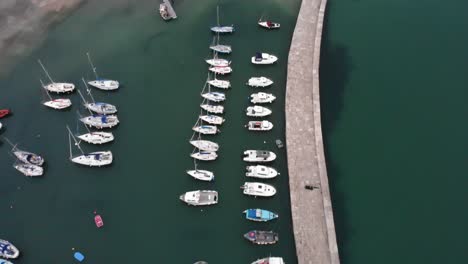 Aerial-shot-of-The-Cobb-harbour-wall-and-moored-boats-at-Lyme-Regis-Dorset-England