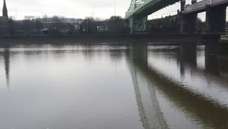 Runcorn-Silver-Jubilee-suspension-bridge-reflections-rippling-in-River-Mersey-below-slow-tilt-down