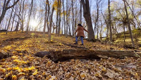 Girl-walking-thru-trees-with-yellow-leaves-beautiful-forest-autumn-in-Minnesota