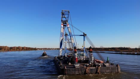 Large-Floating-Sheerleg-Pulled-By-Tug-Boat-In-The-River-At-Daytime-Near-Barendrecht,-Netherlands