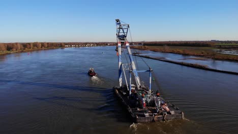 Tugboat-Pulling-Sheerleg-Barge-In-The-River-In-Barendrecht,-Netherlands