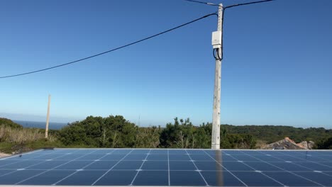 Solar-panel-and-power-line-cable-on-sunny-day-in-coastal-region,-static-view