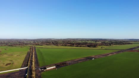 Aerial-panning-left-shot-of-the-old-Airstrip-at-RAF-Upottery-Smeatharpe-Devon-England-on-a-beautiful-summers-day