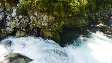 Top-down-shot-of-rocky-stream-flowing-downhill-the-mountains-in-Fiordland-National-Park