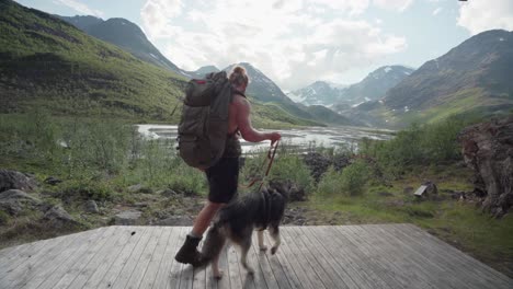 Kaukasischer-Wanderer,-Der-Sich-Mit-Seinem-Hund-Auf-Einem-Pfad-Ausruht-Und-Die-Aussicht-Im-Lyngsdalen-tal-Norwegen-Bewundert---Weitwinkelaufnahme