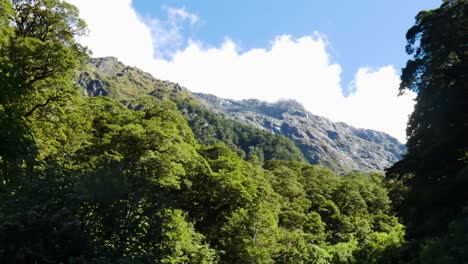 Filmische-Panoramaaufnahme-Von-Massiven-Bergen-Und-Dichten-Grünen-Waldbäumen-Im-Tal